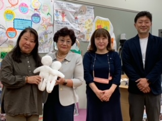 松平理事長にキワニスドールを手渡す瀧会長（右から3人目）